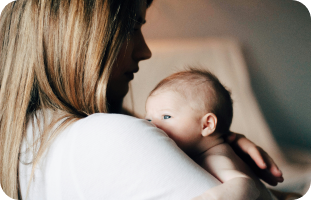 Mother holding her baby, navigating motherhood with Myasthenia Gravis