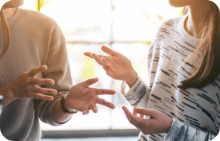 Two people explaining Myasthenia Gravis using hand gestures